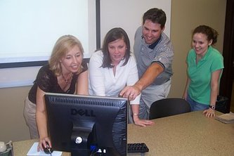 Dr. Wright with students viewing computer